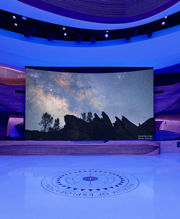 The Media wall in the National Geographic Museum pavilion, lit up at night with the lights off.