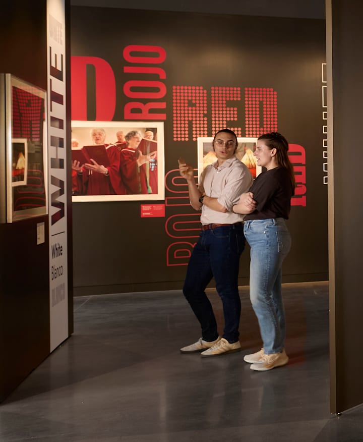 A photo taken from inside the "Red, White & Blue: Photographs of the United States" exhibition shows vibrant framed photography that aligns with the theme. 