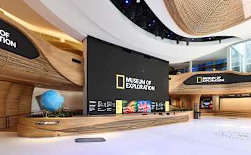 An empty pavilion with a large screen that has Museum of Exploration logo