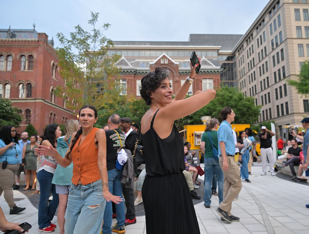 A woman dancing in the National Geographic Museum courtyard.