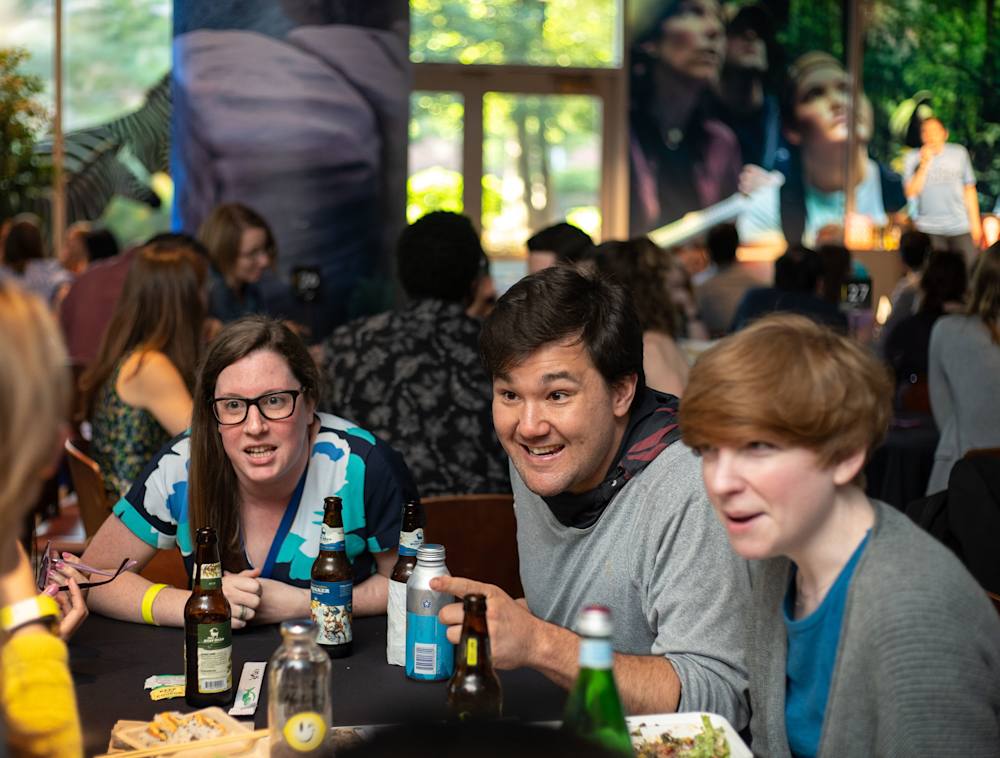A group sitting at a table with drinks playing trivia at National Geographic Trivia Night.