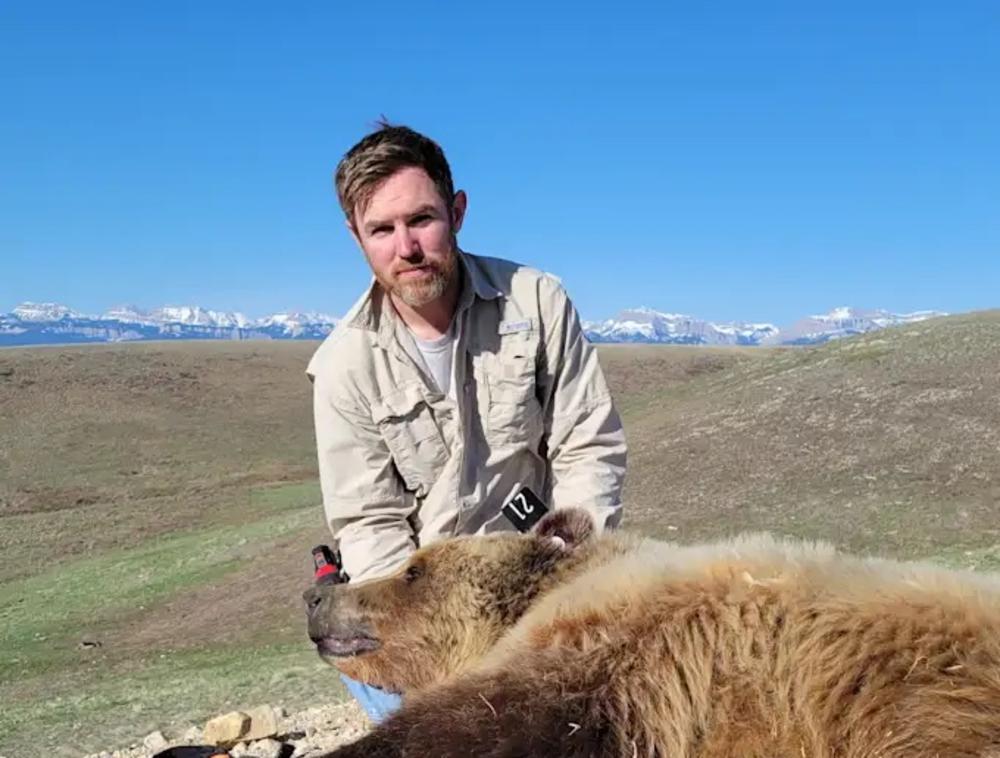 Wesley Sarmento sitting with a bear.