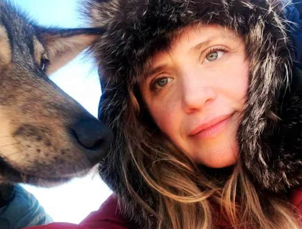 A close up of Katie Orlinsky next to her dog.