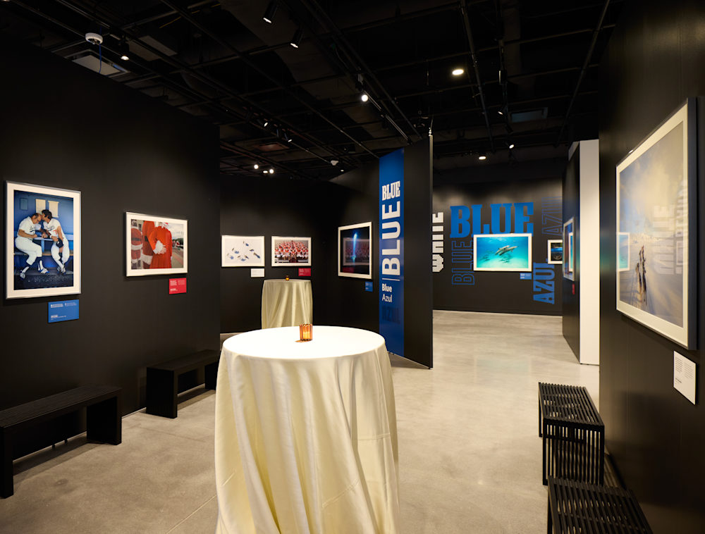 Tall, event tables with white tablecloths in an empty photography gallery. 