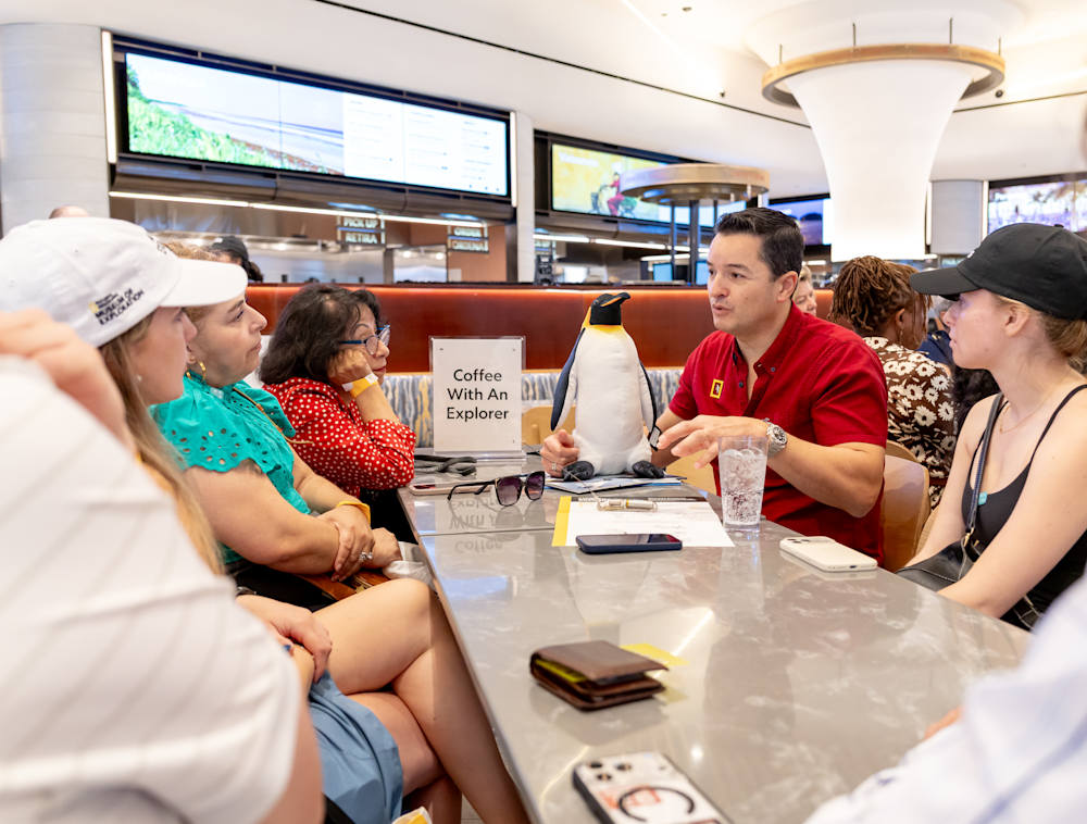 A explorer talking with visitors at the Explorers Eatery in the National Geographic Museum.