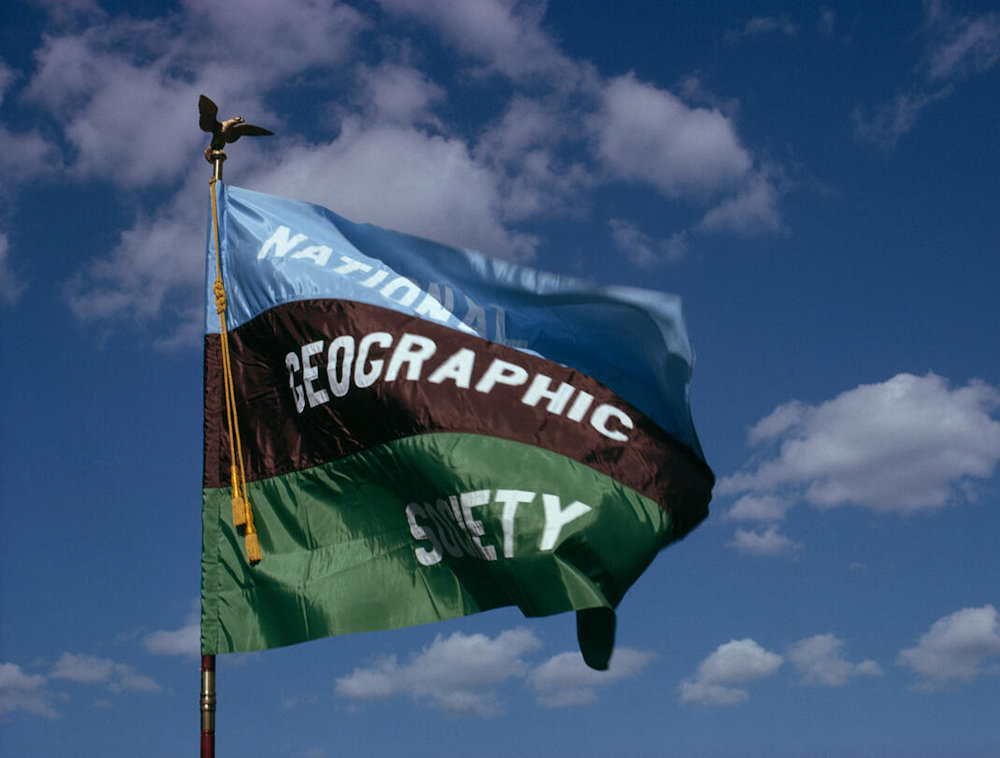 The National Geographic Society flag waving in the sky.