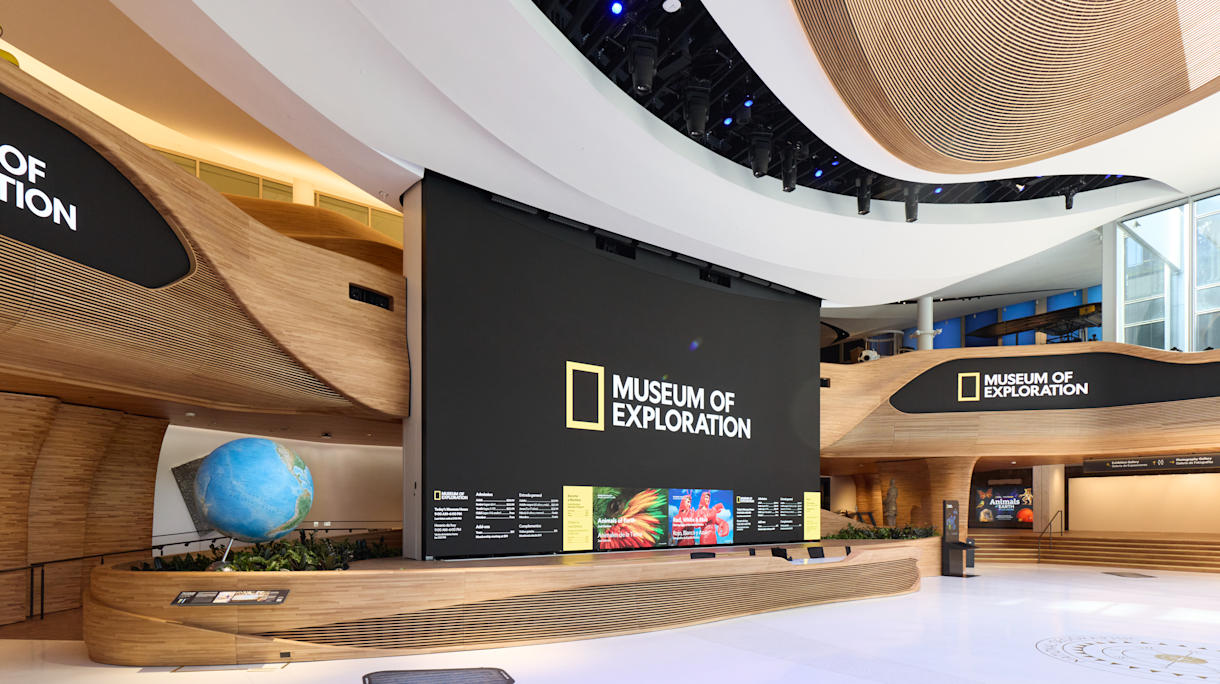 Vista lateral del Pabellón. Una pantalla gigante en el centro del espacio muestra el logotipo del museo y, debajo, los precios de los boletos de entrada. 