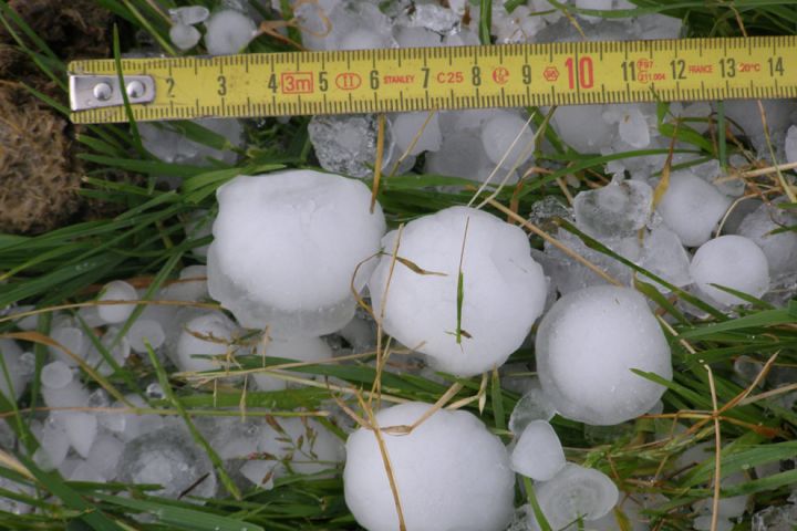 Photo:  Measurements being taken of large hail stones