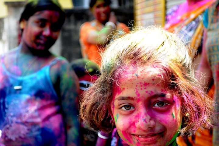 Photo of a girl covered in pink powder.