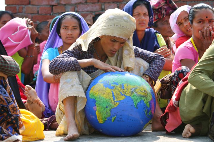 Photograph of woman looking at an inflatable globe.