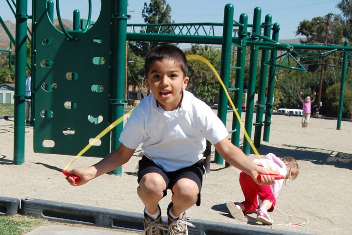 Photo: Boy jumps rope at a playground.