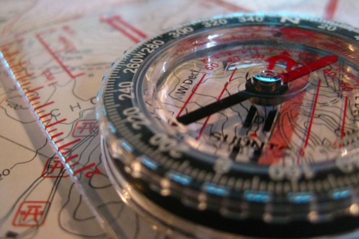 Photograph of a compass, ruler and map.