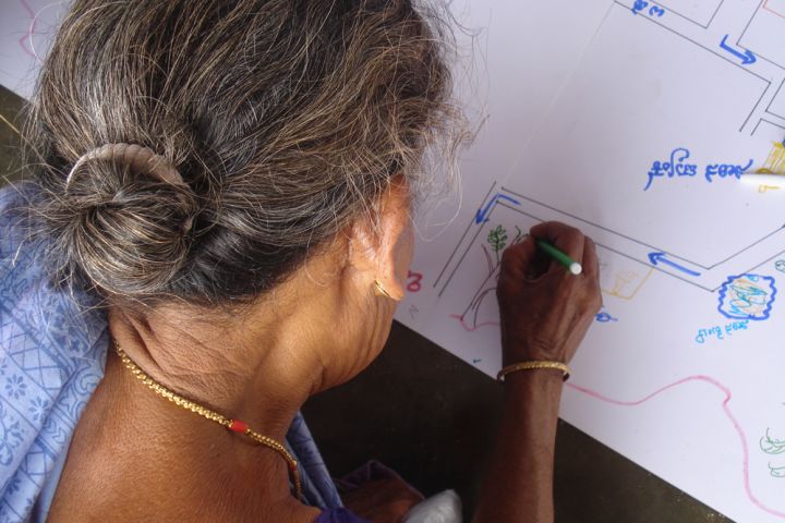 Photograph of a woman participating in a public participatory mapping project in India.