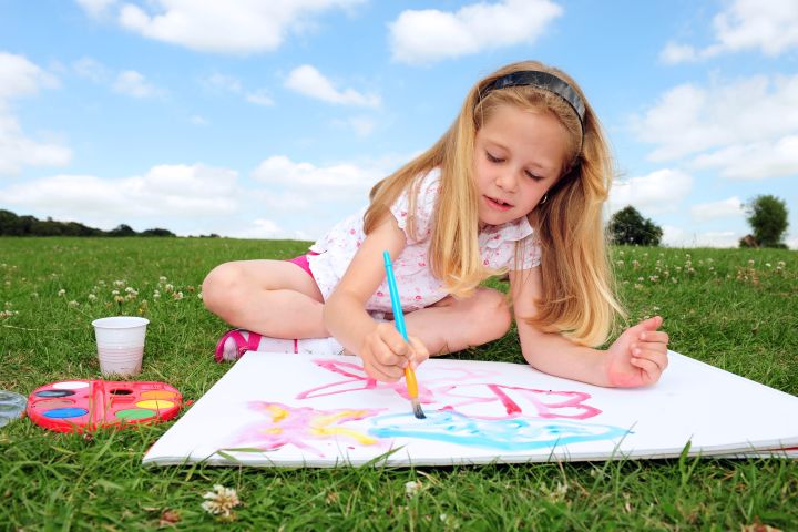 young girl drawing in the park