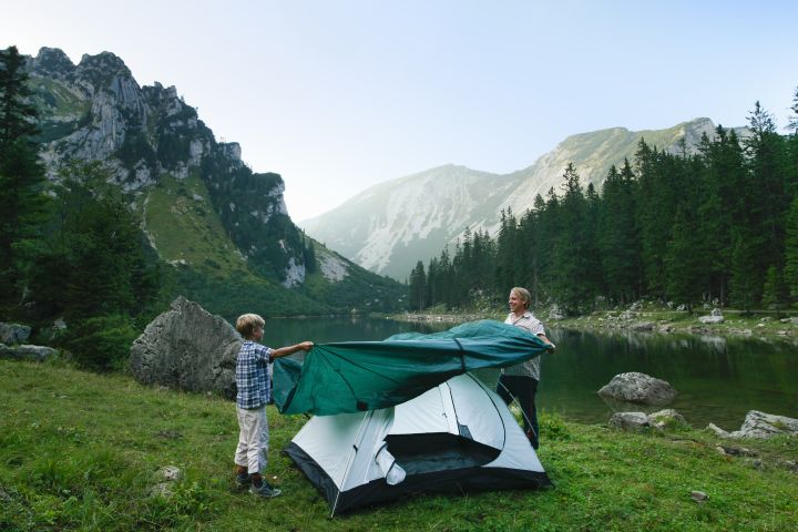 Father and son pitching tent together