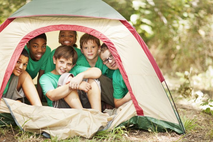 Students sitting in camp tent