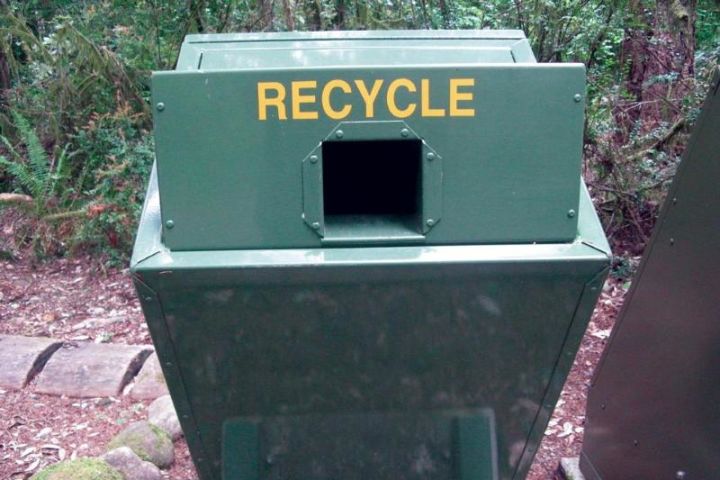 A Photograph of a green recycling bin located in Redwood National and State Parks.
