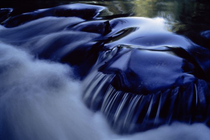 A photograph of water flowing over rocks in the rapids of Shenandoah River.