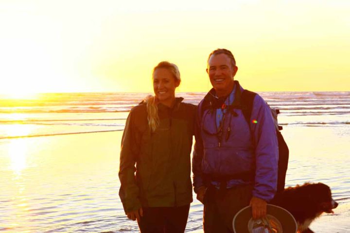 Photo: A man and woman on the coast during a sunset.