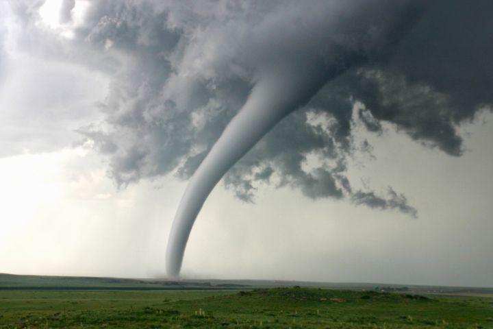 Image of a tornado streaking across a rural field.