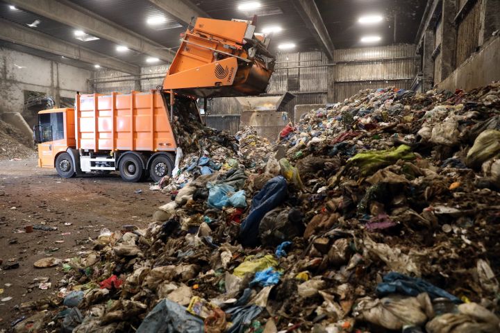 A dump truck unloads its waste in a recycling facility