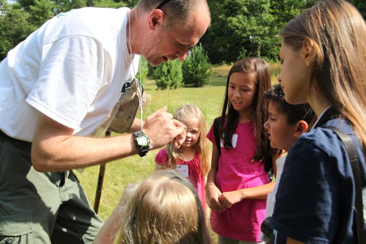 Matt Burne (left) teaches children how to distinguish different species of dragonfly during a class trip.