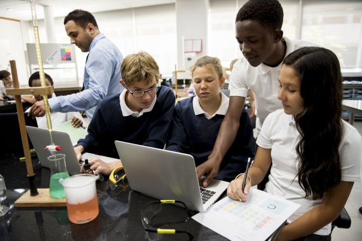 High school students working on an assignment together in a chemistry class.