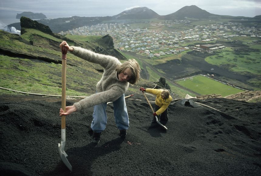 Removing volcanic ash can be a difficult and laborious process. Here, two Icelanders shovel volcanic ash from a hillside in Vestmannaeyjar, a volcanic archipelago off the southwest coast of Iceland.
