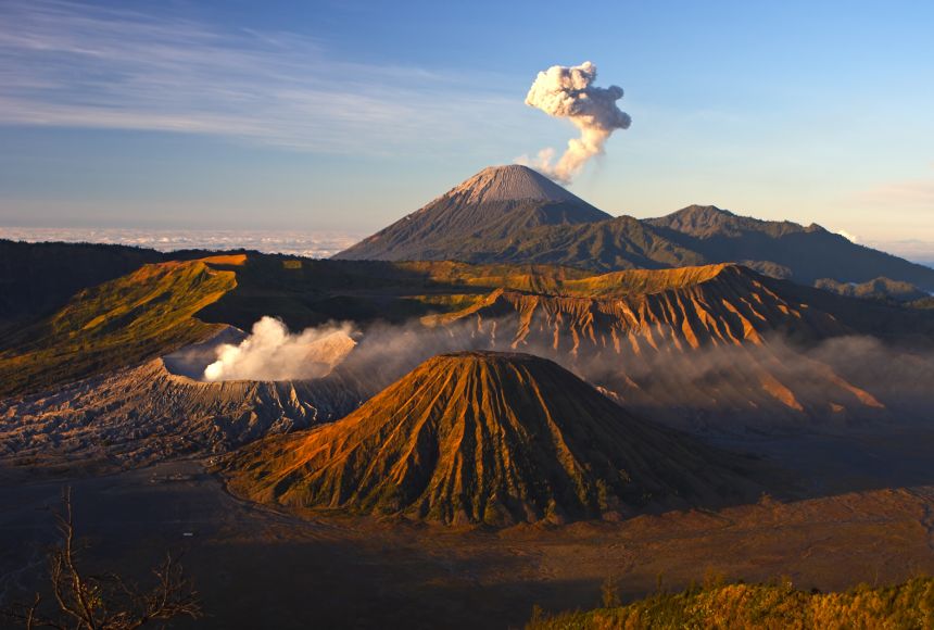 Bromo Tengger Semeru National Park on the island of Java (Jawa), Indonesia, is home to several active volcanoes, which can be seen here smoking ominously against a blue sky.
