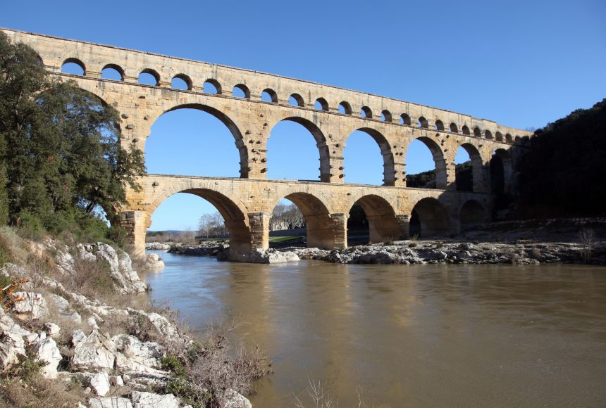This is the Roman aqueduct of Pont du Gard, which crosses the Gard river, France. It is a UNESCO World Heritage Site.