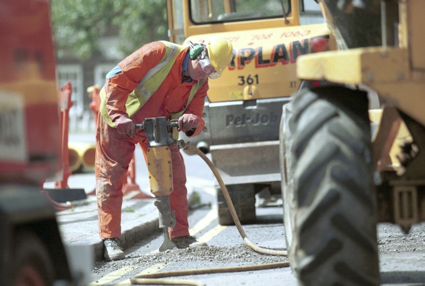 A man working with a jackhammer in a construction site. Noise pollution becomes and increasingly larger issue in big cities.
