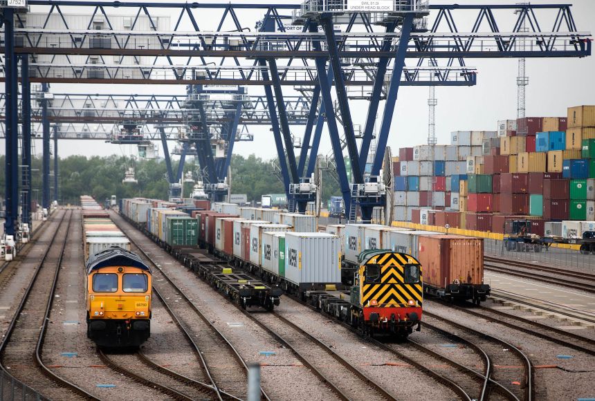 Freight trains waiting to be loaded with cargo to transport around the United Kingdom. This cargo comes from around the world and contains all kinds of goods and products.
