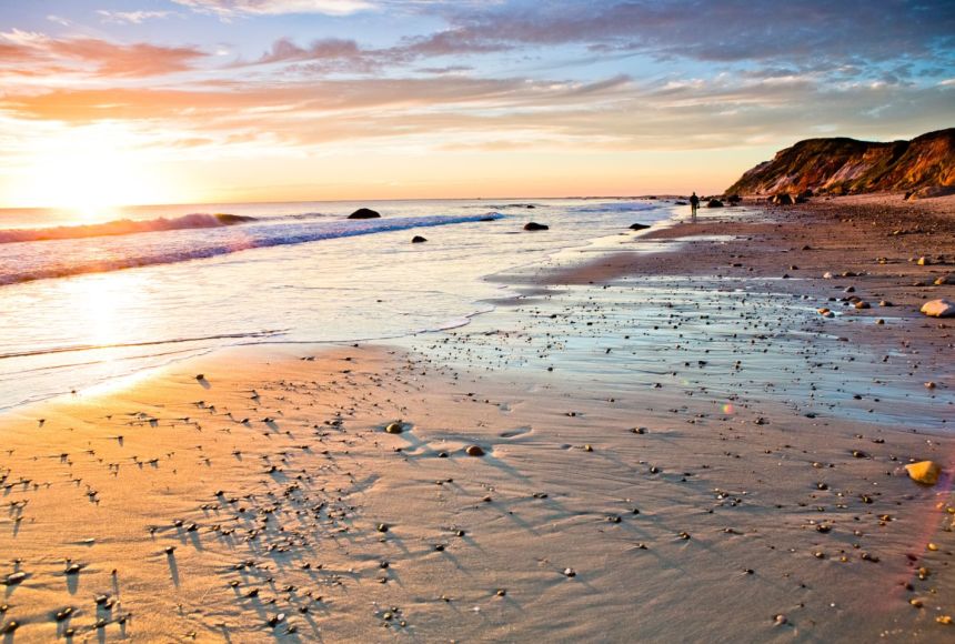 The sunsets to on the left throwing it's vibrant colors on the sandy shore.