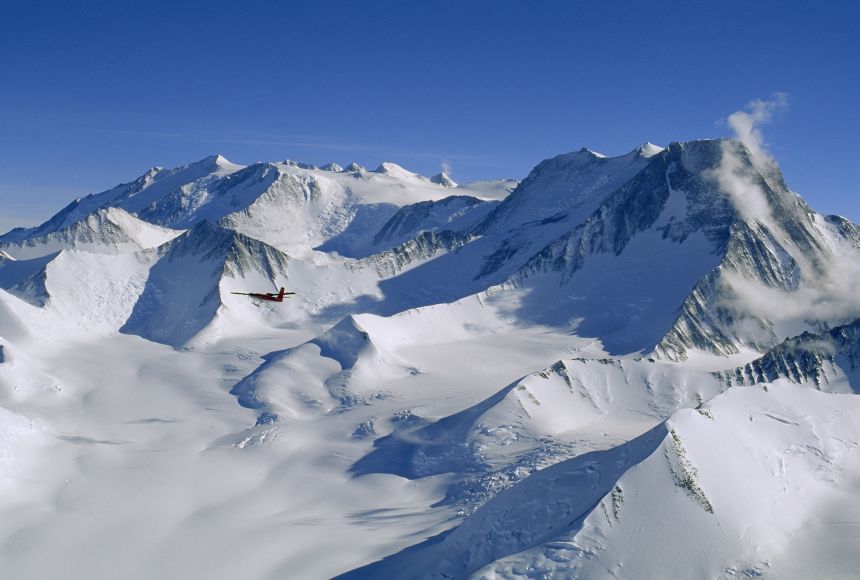 An aircraft flies by Mount Vinson, which at 4,892 meters (16,050 feet), is Antarctica's highest summit. Along with five other, nearby, tall mountains, it forms the Mount Vinson Massif.
