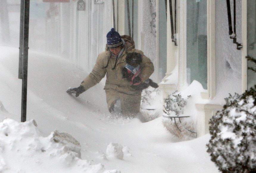 Nor'easters are common to the United States' East Coast, bringing heavy precipitation, often snow. Cathleen Cahill carries her dog Chikita through the deep snow caused by a January 2015 nor'easter in downtown Rockport, Massachusetts.