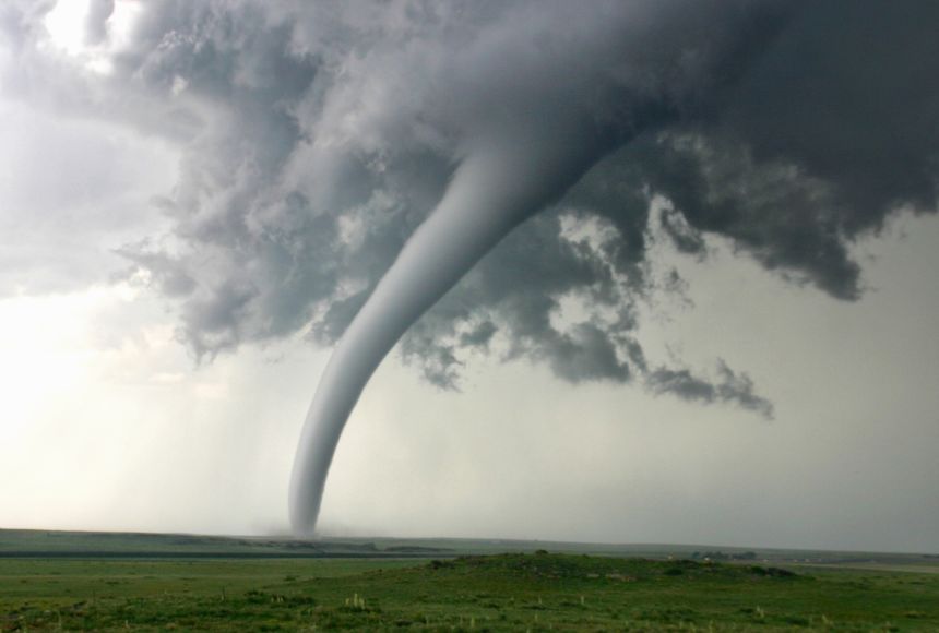 Image of a tornado streaking across a rural field.
