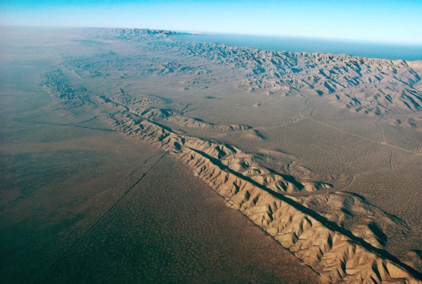 Tectonic plate boundaries, like the San Andreas Fault pictured here, can be the sites of mountain-building events, volcanoes, or valley or rift creation.