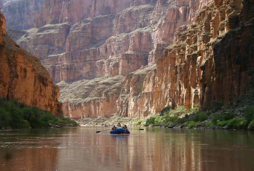 A photograph of boaters rowing past the Grand Canyon along the Colorado River below Havasu Creek, Arizona, United States.