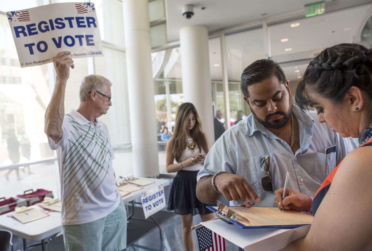 A new citizen of the United States, right, registers to vote after a naturalization ceremony at the Evo A. DeConcini U.S. Courthouse in Tucson, Arizona, on Sept. 16, 2016.